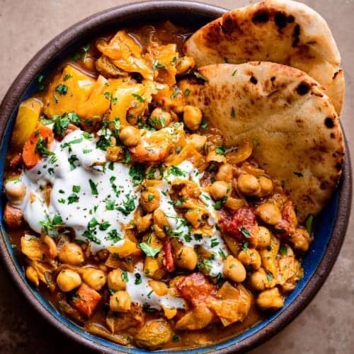 braised indian chickpea stew in bowl with naan and yogurt 1 of 1 500×500